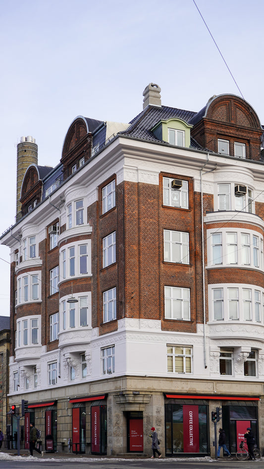 Corner of a multi-story building with architectural details on a clear day
